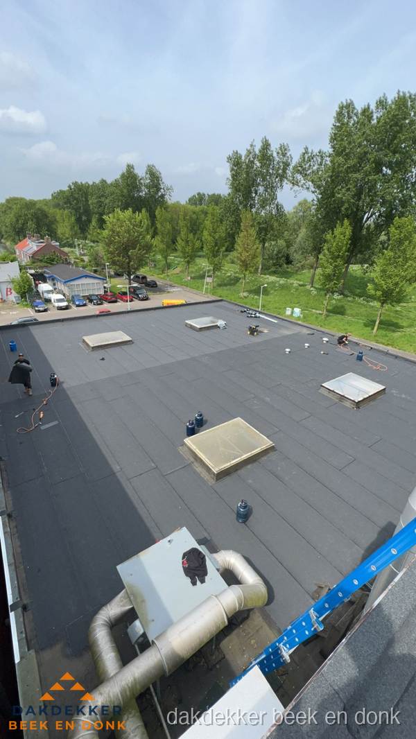 Dakdekker aan het werk op groot plat dak met bitumen in Beek en Donk Dakdekker aan het werk op groot plat dak met bitumen in Beek en Donk