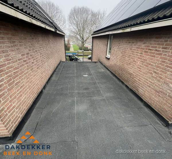 Plat dak met bitumen dakbedekking tussen bakstenen muren in Beek en Donk Plat dak met bitumen dakbedekking tussen bakstenen muren in Beek en Donk