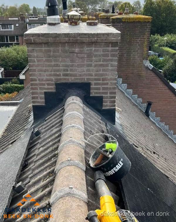 Schoorsteen met loodaansluiting en nokvorst op pannendak in Beek en Donk
