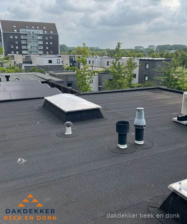 Groot plat dak met lichtkoepel en dakdoorvoeren in Beek en Donk