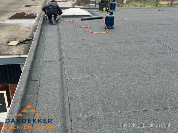 Dakdekker repareert bitumen dakbedekking op groot plat dak in Beek en Donk Dakdekker repareert bitumen dakbedekking op groot plat dak in Beek en Donk