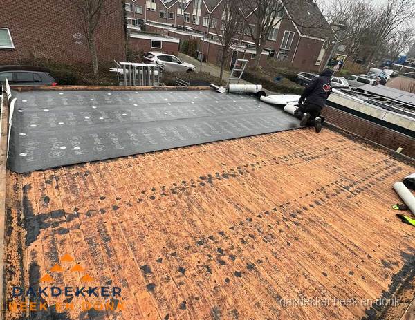 Dakdekker legt onderlaag op plat dak met houten constructie in Beek en Donk